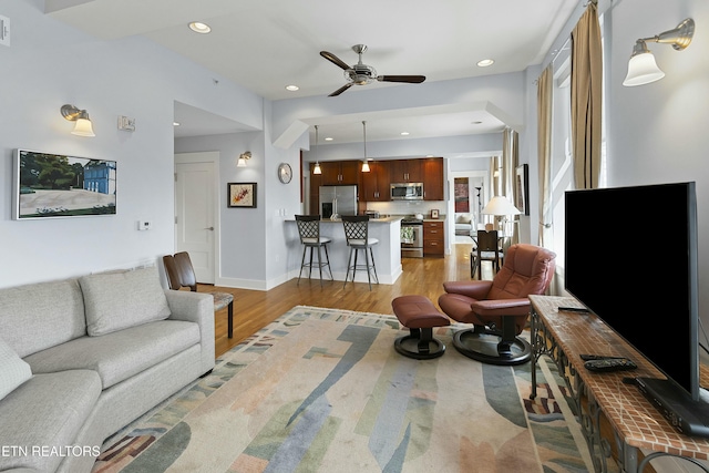 living room with visible vents, a ceiling fan, recessed lighting, light wood-style floors, and baseboards