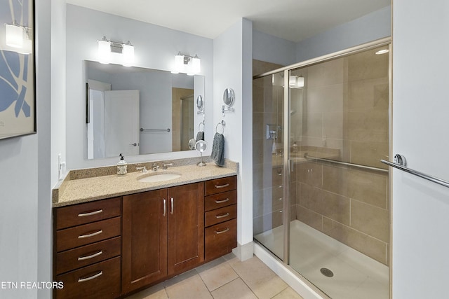 full bath with tile patterned flooring, a stall shower, and vanity