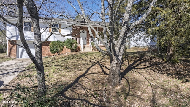 view of front of home with a garage, concrete driveway, and brick siding