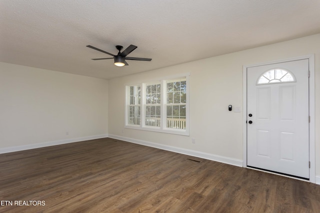 entrance foyer with dark wood-style floors, a textured ceiling, and baseboards