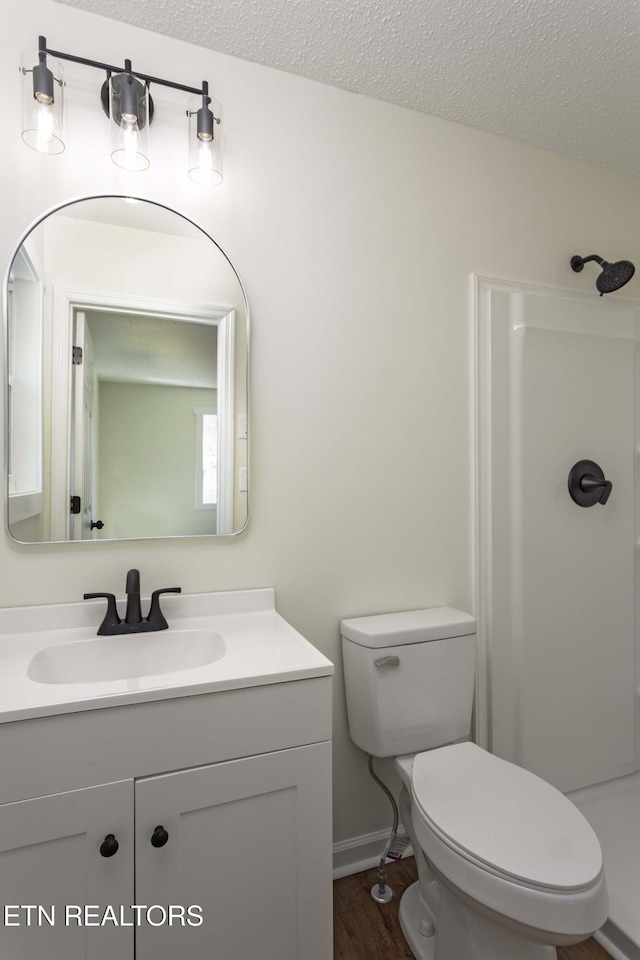 full bathroom featuring toilet, a walk in shower, a textured ceiling, and wood finished floors