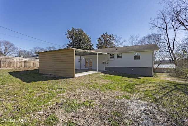 rear view of house with fence, a patio, and a lawn