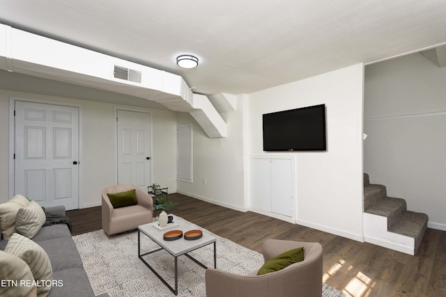 living room featuring stairs, wood finished floors, visible vents, and baseboards