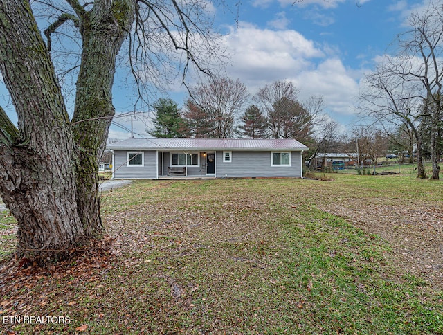 view of front of home with metal roof and a front yard