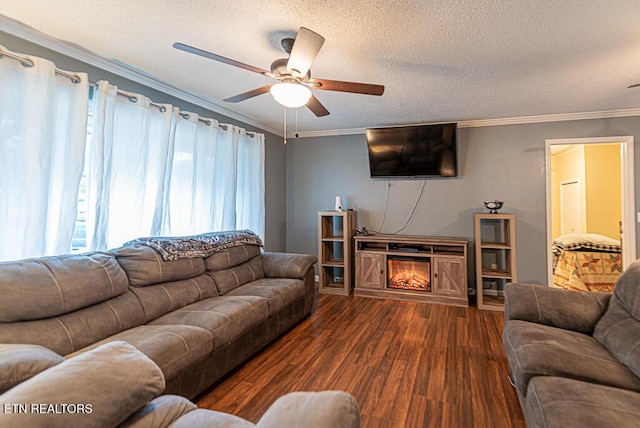 living room featuring crown molding, a lit fireplace, a textured ceiling, and wood finished floors