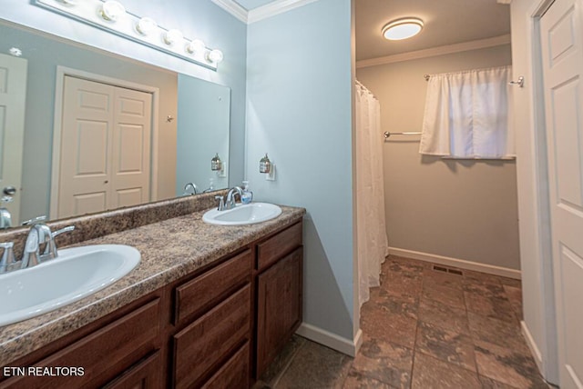 full bathroom featuring double vanity, crown molding, baseboards, and a sink