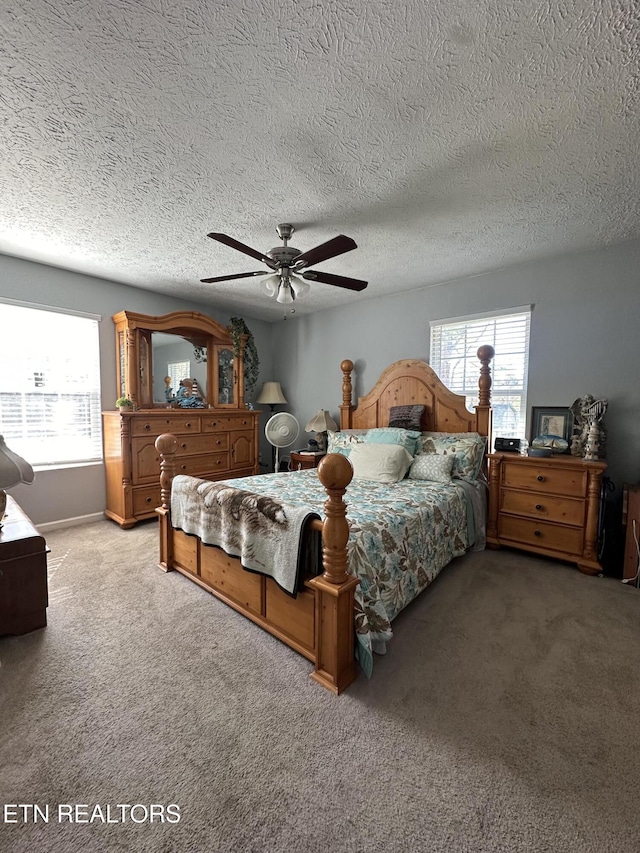 bedroom featuring ceiling fan, multiple windows, baseboards, and light colored carpet