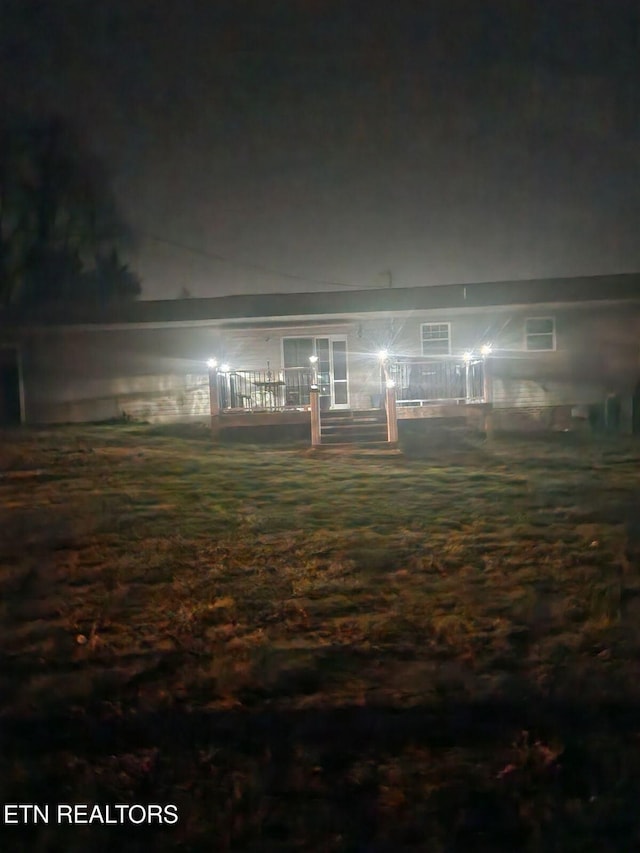 back of house at twilight with a wooden deck