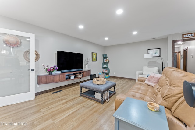 living area featuring light wood finished floors, baseboards, visible vents, and recessed lighting