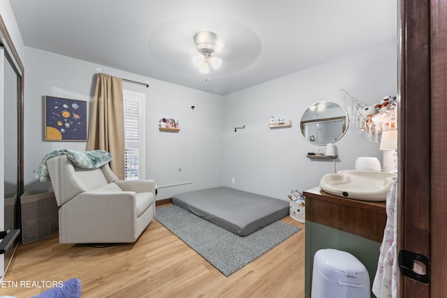 bedroom with a closet, a sink, light wood finished floors, and ceiling fan