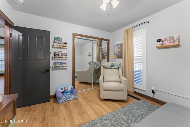 bedroom featuring ceiling fan, a closet, wood finished floors, and baseboards