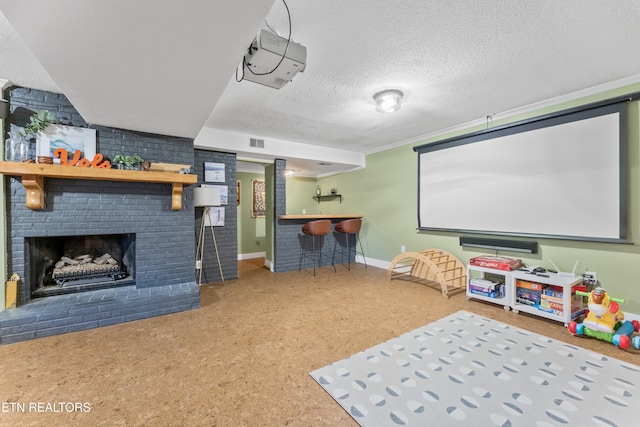 home theater featuring visible vents, a brick fireplace, a textured ceiling, a bar, and baseboards