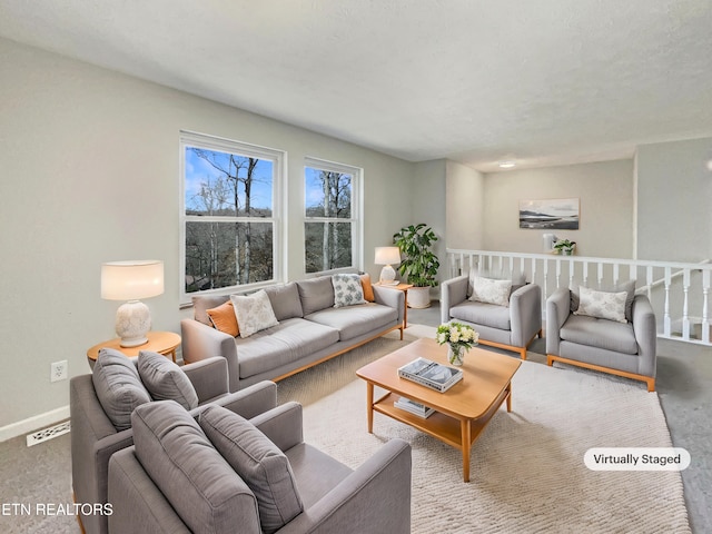 living area with carpet flooring, visible vents, and baseboards