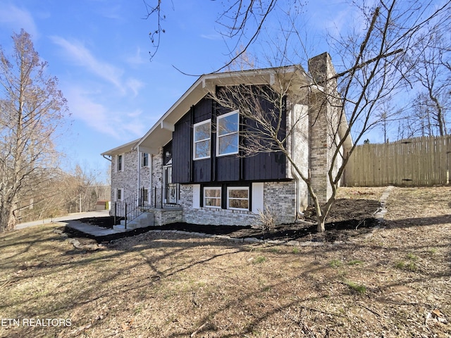 exterior space featuring a chimney and fence