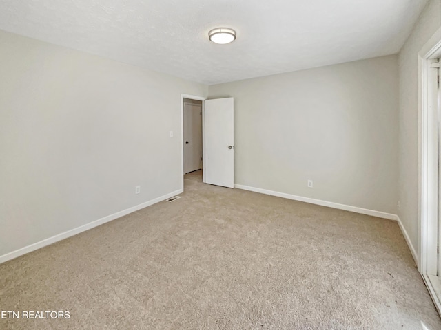 empty room with baseboards and light colored carpet