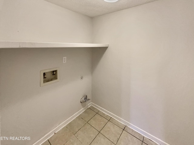 laundry room with a textured ceiling, light tile patterned floors, hookup for a gas dryer, laundry area, and washer hookup