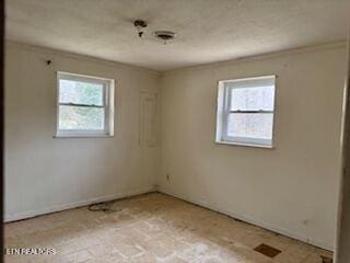 spare room with ornamental molding and a textured ceiling