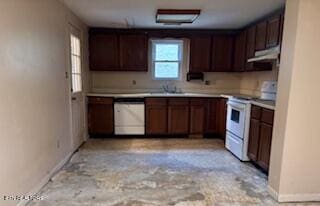 kitchen featuring white appliances, light countertops, under cabinet range hood, and baseboards