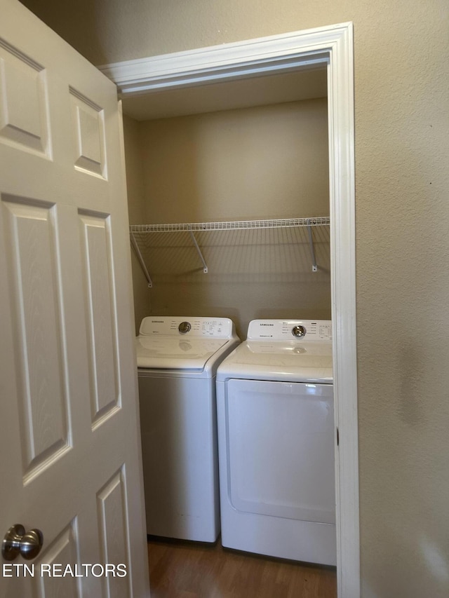 washroom featuring washing machine and clothes dryer and dark wood-type flooring