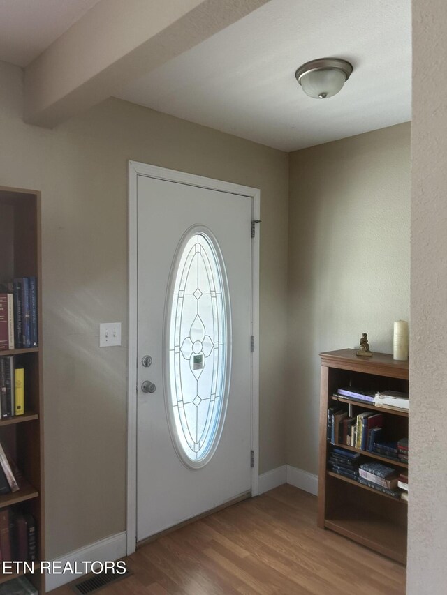foyer entrance featuring baseboards and wood finished floors