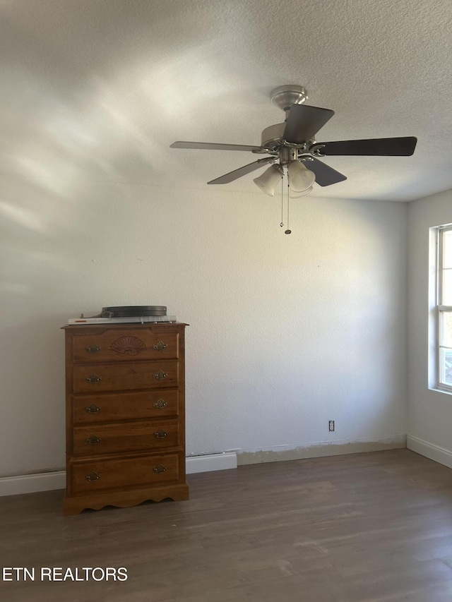 unfurnished bedroom featuring wood finished floors, a ceiling fan, and baseboards