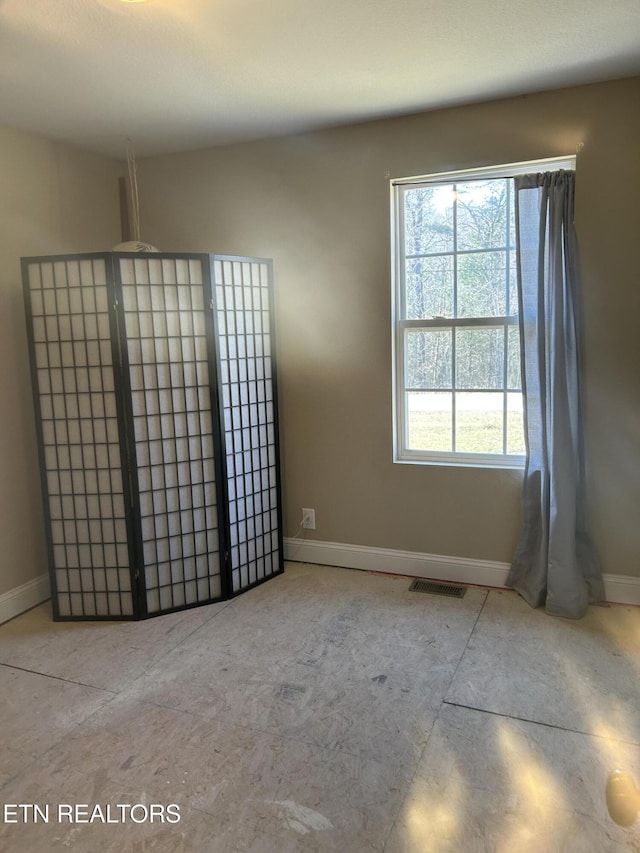 unfurnished room featuring visible vents and baseboards