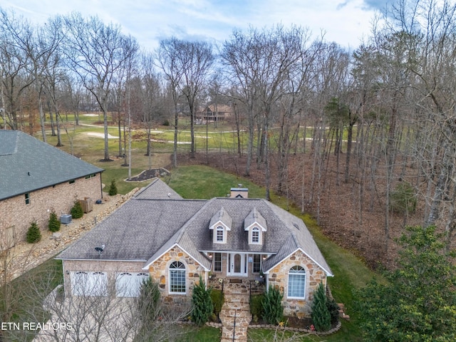 exterior space featuring stone siding and a front lawn