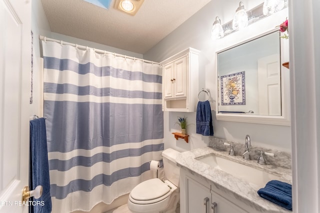 bathroom with a textured ceiling, toilet, vanity, and a shower with curtain