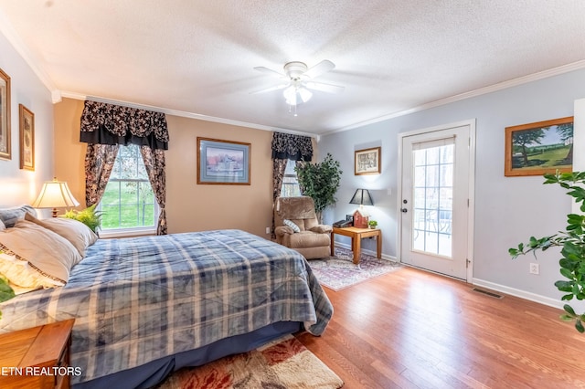 bedroom with access to outside, wood finished floors, visible vents, and multiple windows