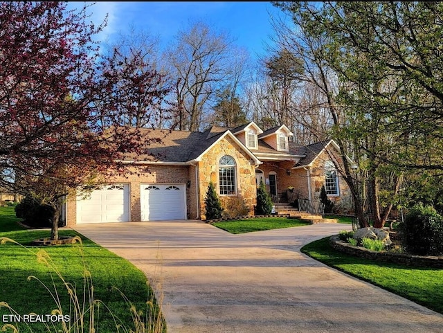 view of front of home with brick siding, an attached garage, stone siding, driveway, and a front lawn