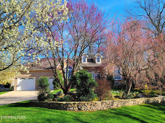 31 Oakcrest Ct, Crossville, TN 38558 - obstructed view of property featuring a front yard, brick siding, concrete driveway, and a garage