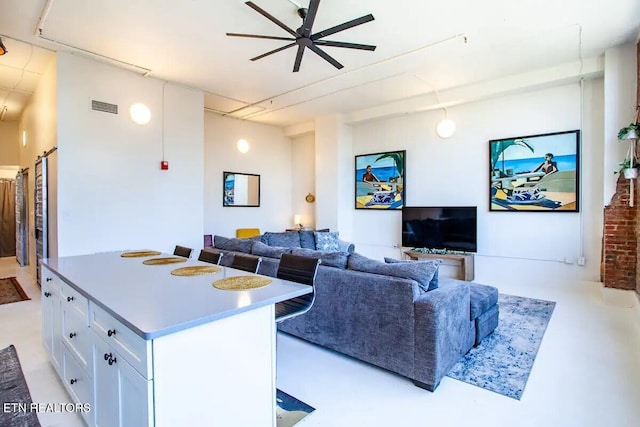 living area with a ceiling fan and visible vents
