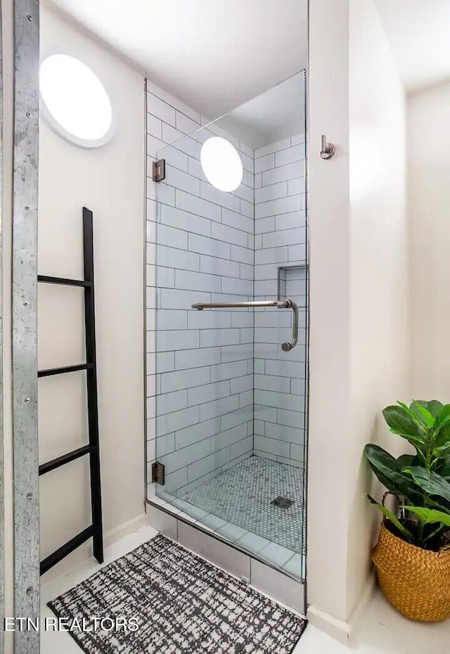 bathroom featuring baseboards and a shower stall