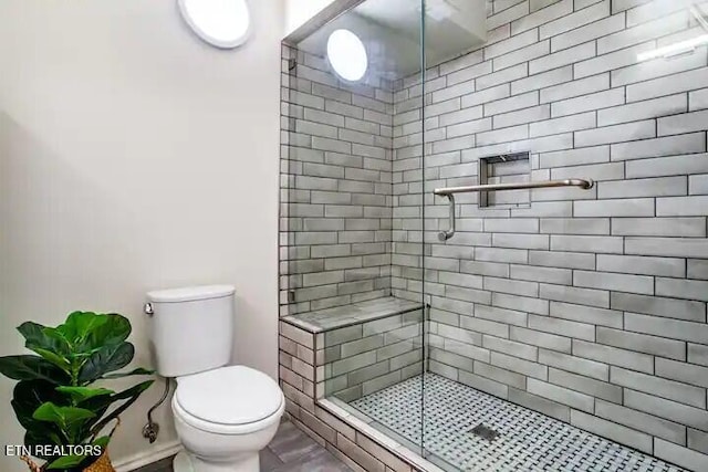 bathroom with a shower stall and toilet