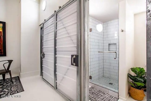 bathroom with baseboards and a stall shower