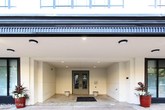 entrance to property featuring stucco siding and french doors