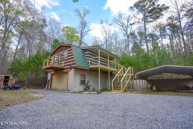 1435 Old Chisholm Trl, Dandridge, TN 37725 - view of front of house with a gambrel roof, gravel driveway, metal roof, a wooden deck, and stairs