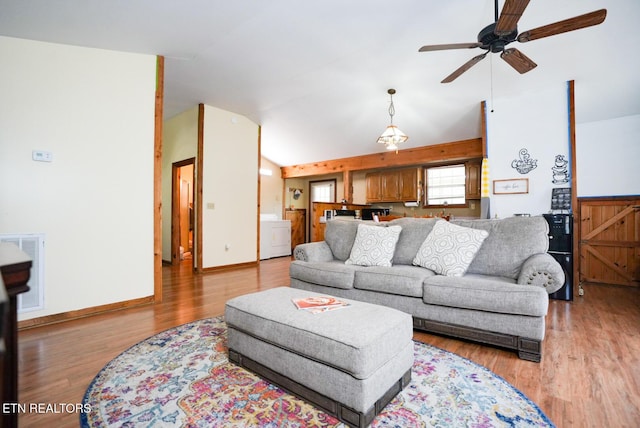 1435 Old Chisholm Trl, Dandridge, TN 37725 - living room featuring lofted ceiling, ceiling fan, washer / clothes dryer, light wood-style floors, and baseboards