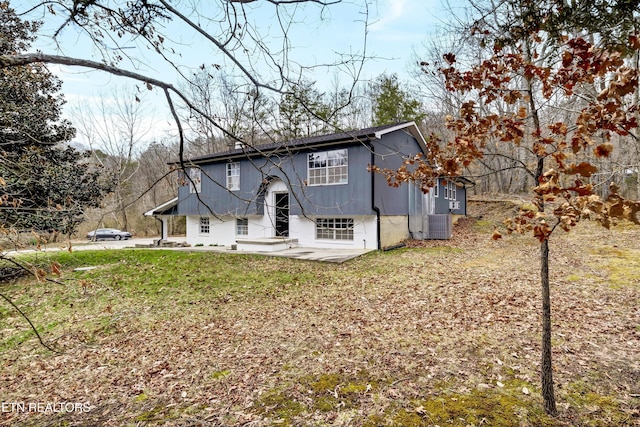 view of front of property featuring a front yard, a patio area, and central AC