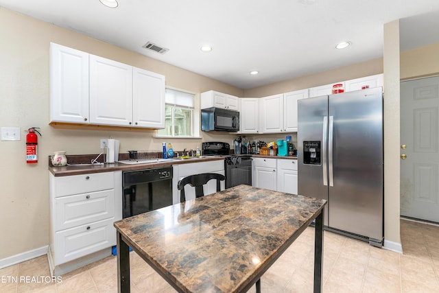 kitchen featuring dark countertops, visible vents, black appliances, and white cabinetry