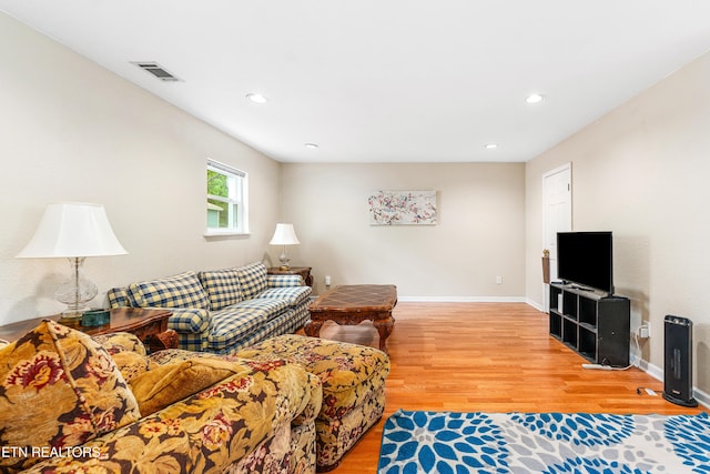 living room featuring visible vents, baseboards, light wood-type flooring, and recessed lighting