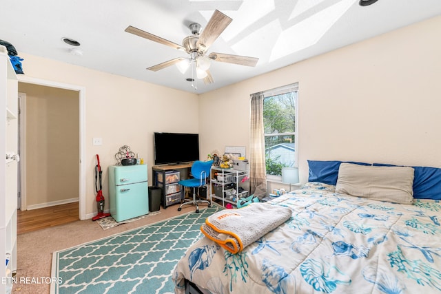bedroom with baseboards, carpet floors, a ceiling fan, and a skylight