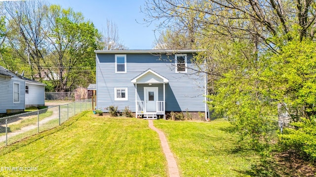 rear view of house featuring a yard and fence