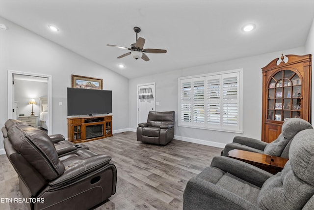 living room with lofted ceiling, recessed lighting, wood finished floors, and baseboards