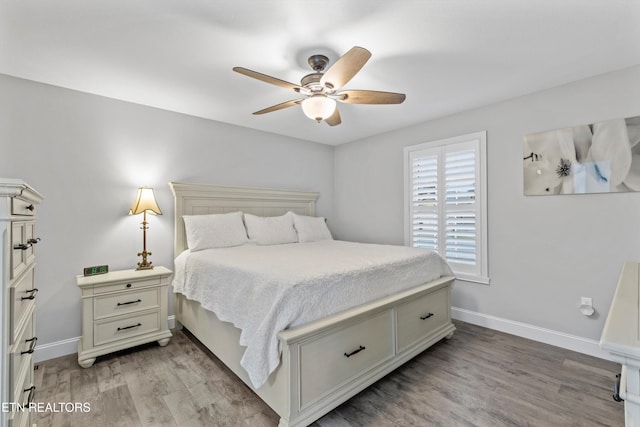 bedroom with a ceiling fan, baseboards, and light wood finished floors