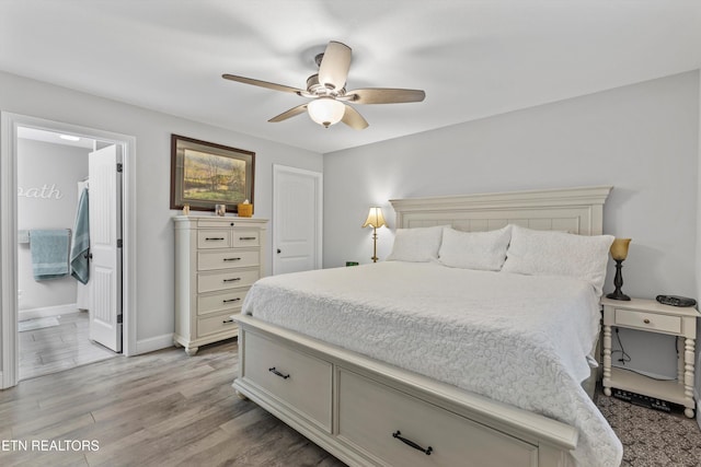 bedroom with connected bathroom, a ceiling fan, light wood-type flooring, and baseboards