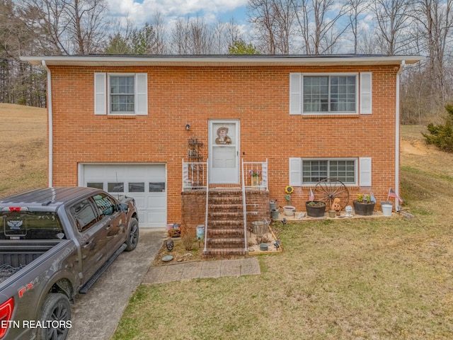 raised ranch with a front lawn, an attached garage, brick siding, and driveway