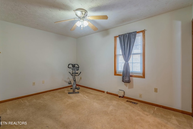 unfurnished room with baseboards, a textured ceiling, a ceiling fan, and carpet