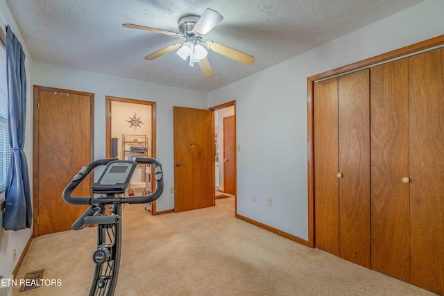 workout room featuring baseboards, a textured ceiling, carpet, and a ceiling fan