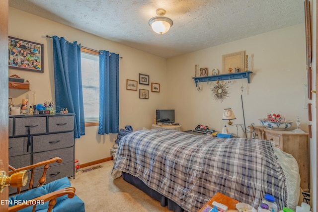 bedroom featuring carpet flooring, baseboards, visible vents, and a textured ceiling